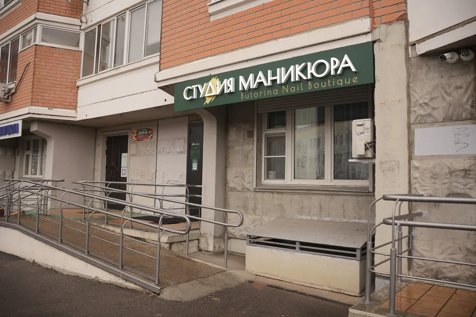 Фасад дома с вывеской и пандусом